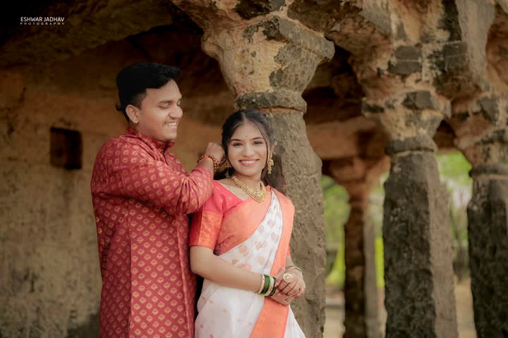 Groom gently touching the bride’s hair beneath the stone arches